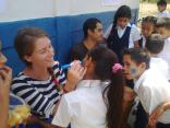 A volunteer paints faces during a dynamic activity at one of the schools.
